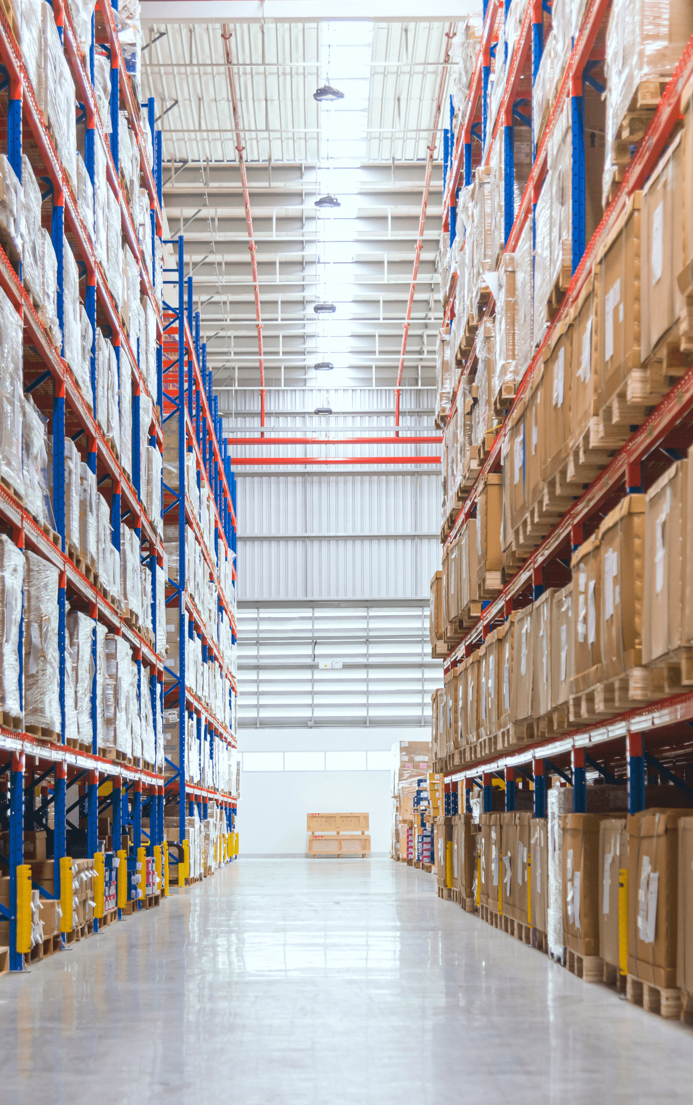 Warehouse aisle with rows of shipments stacked and sorted on tall metal shelving.